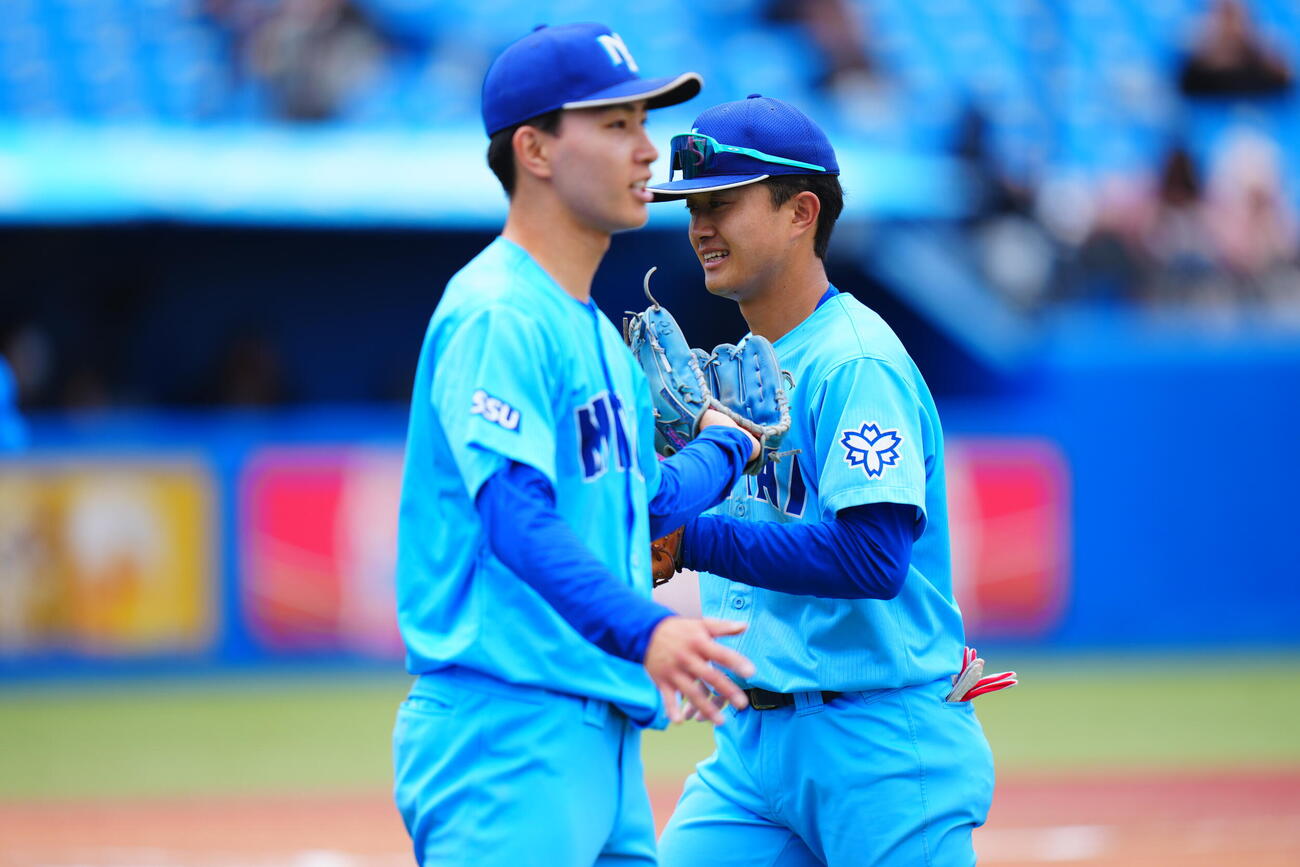 全日本大学野球選手権　2回戦　日体大対周南公立大　6回裏周南公立大の攻撃を無失点で抑えた日体大先発生盛亜勇太（左）と笑顔でタッチを交わす藤巻一洸（撮影・垰建太）