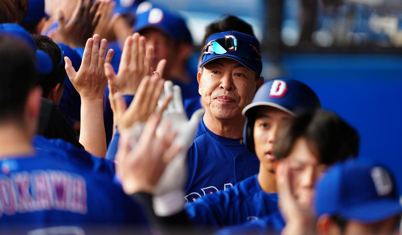 ロッテ対中日　試合前、ベンチでナインとハイタッチする中日井上一樹監督（撮影・鈴木みどり）