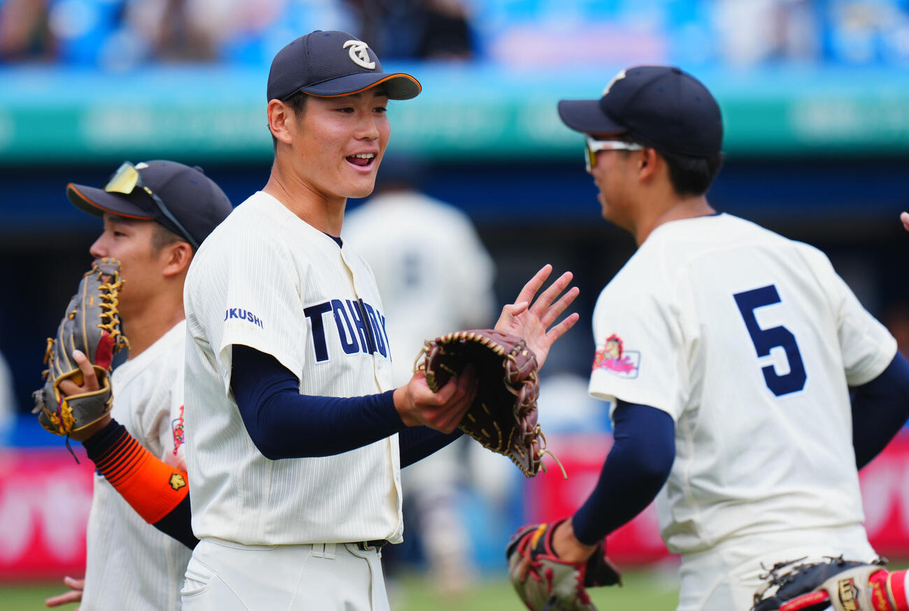 全日本大学野球選手権　準々決勝　大商大対東北福祉大　4回表大商大の攻撃を無失点に抑え笑顔でナインとタッチを交わす東北福祉大先発猪俣駿太（中央）（撮影・垰建太）