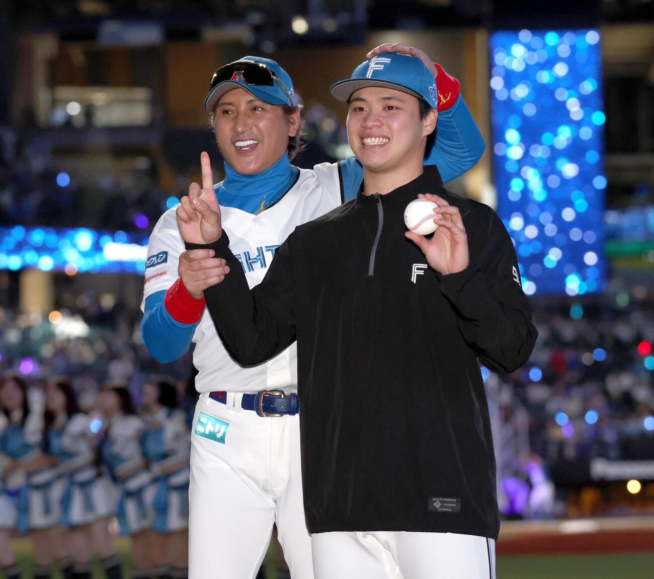 日本ハム対DeNA　プロ初勝利を挙げ新庄剛志監督（左）から祝福される孫易磊（撮影・黒川智章）