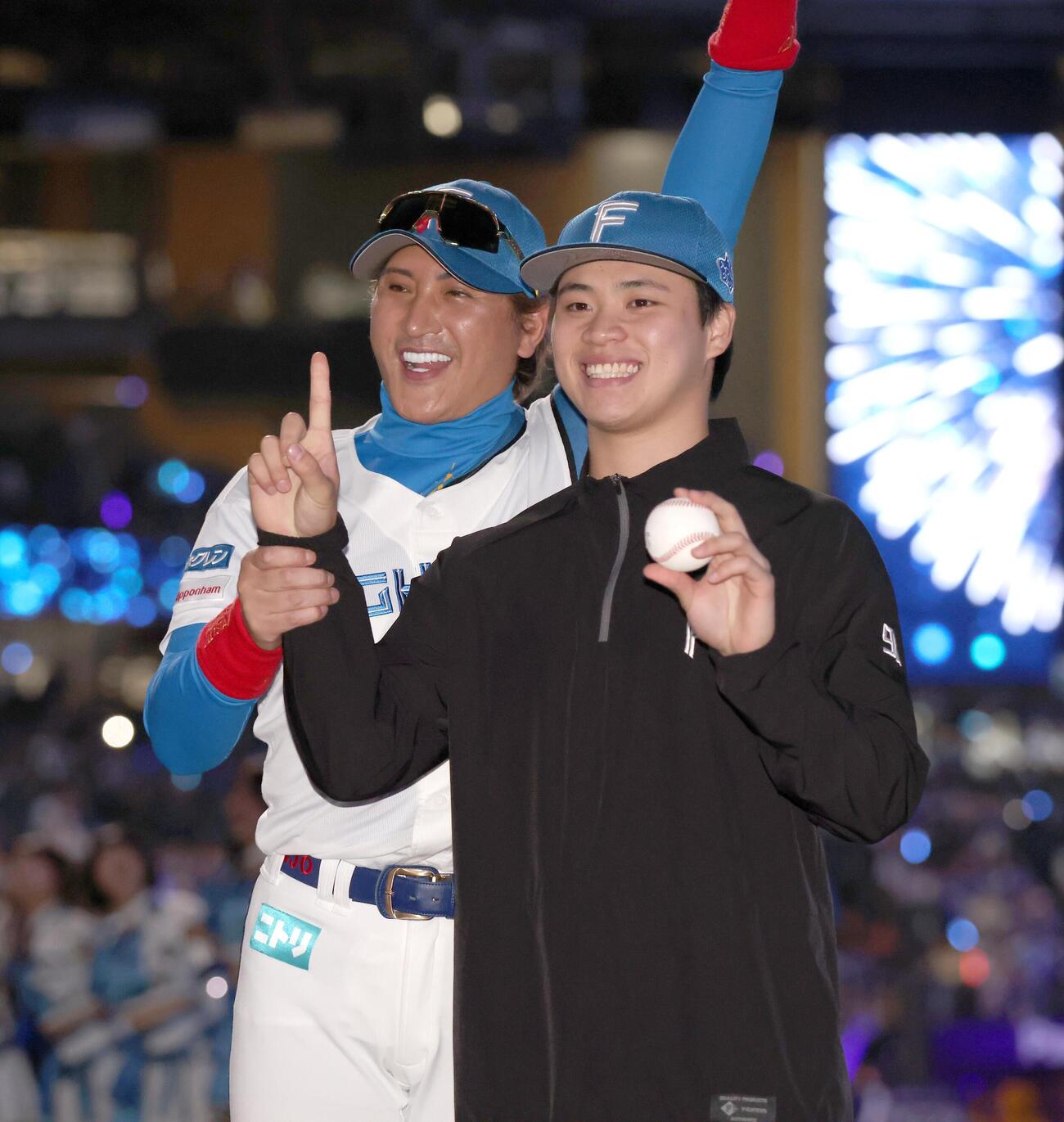 日本ハム対DeNA　プロ初勝利を挙げ新庄剛志監督（左）から祝福される孫易磊（撮影・黒川智章）