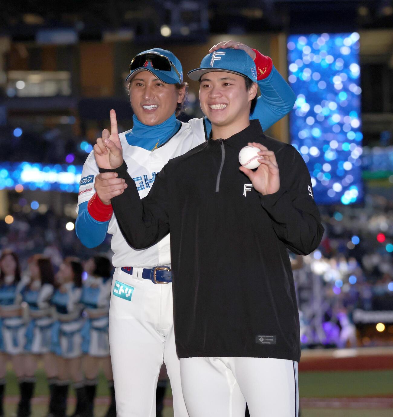 日本ハム対DeNA　プロ初勝利を挙げ新庄剛志監督（左）から祝福される孫易磊（撮影・黒川智章）