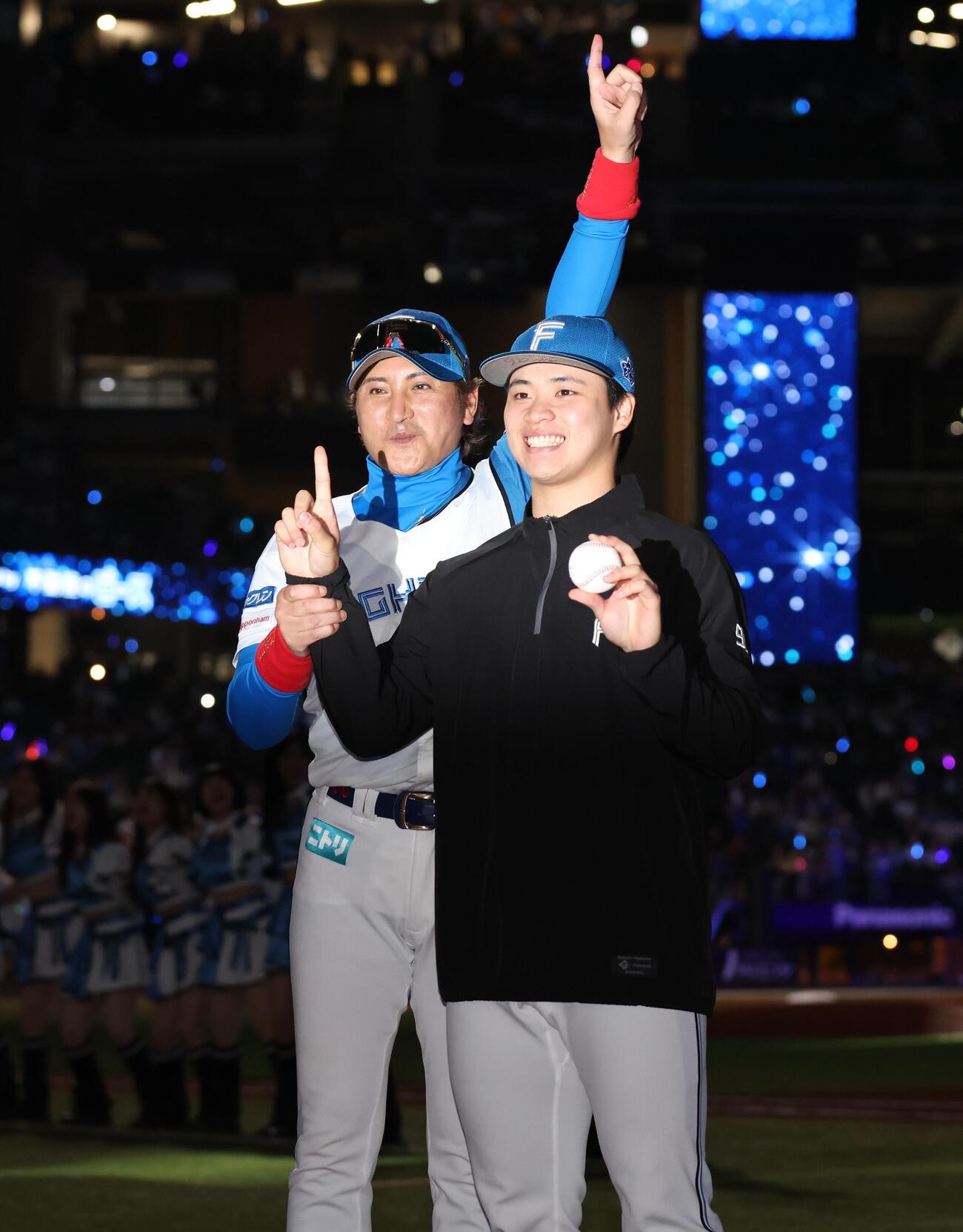 日本ハム対DeNA　プロ初勝利を挙げ新庄剛志監督（左）から祝福される日本ハム孫易磊（撮影・黒川智章）