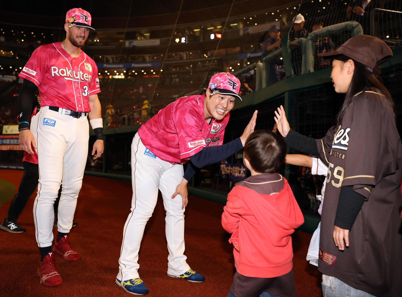 楽天対巨人　楽天マッカスカー（左）と滝中瞭太は場内1周で子供ファンとハイタッチ（撮影・浅見桂子）