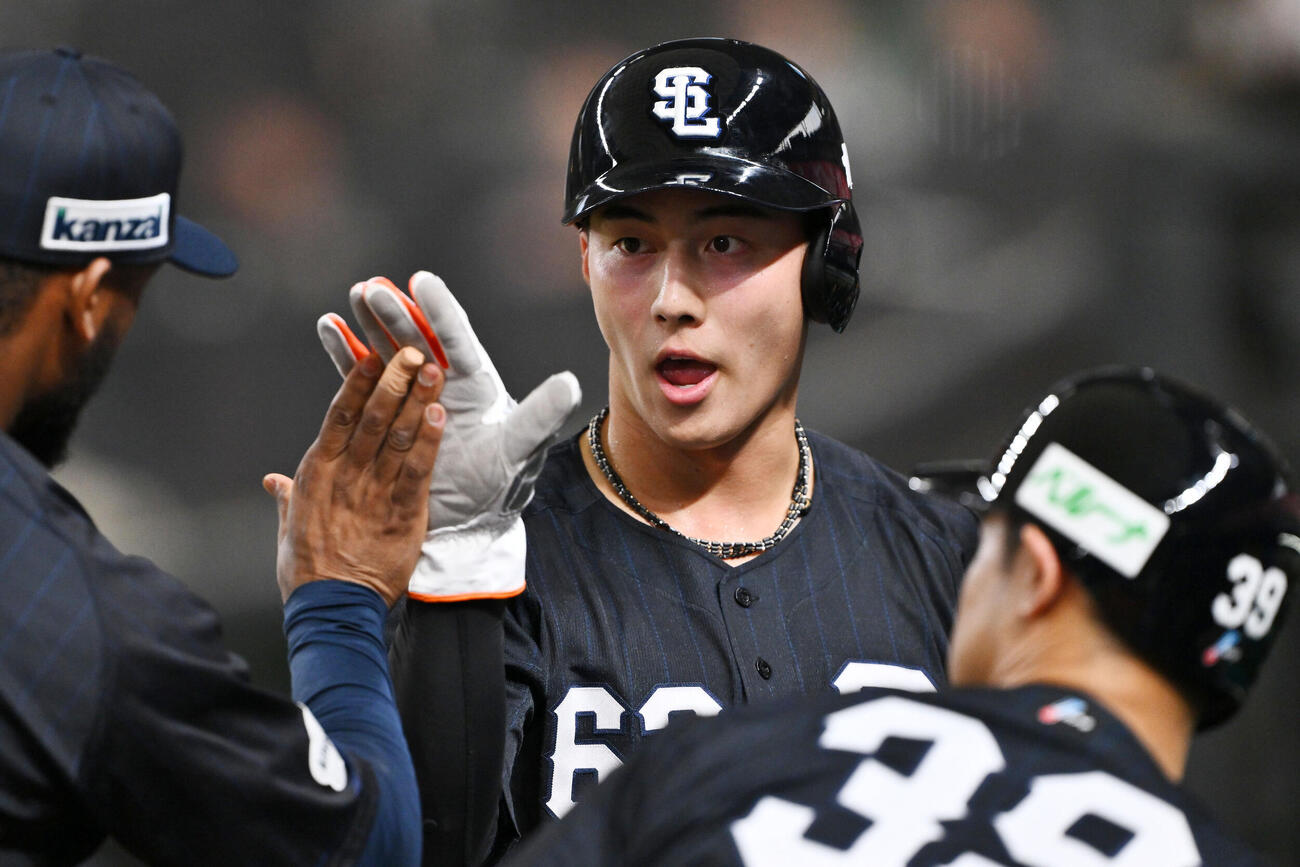西武対巨人　1回裏に先制適時二塁打を放った西武長谷川信哉はチームメートとタッチをかわす（撮影・滝沢徹郎）