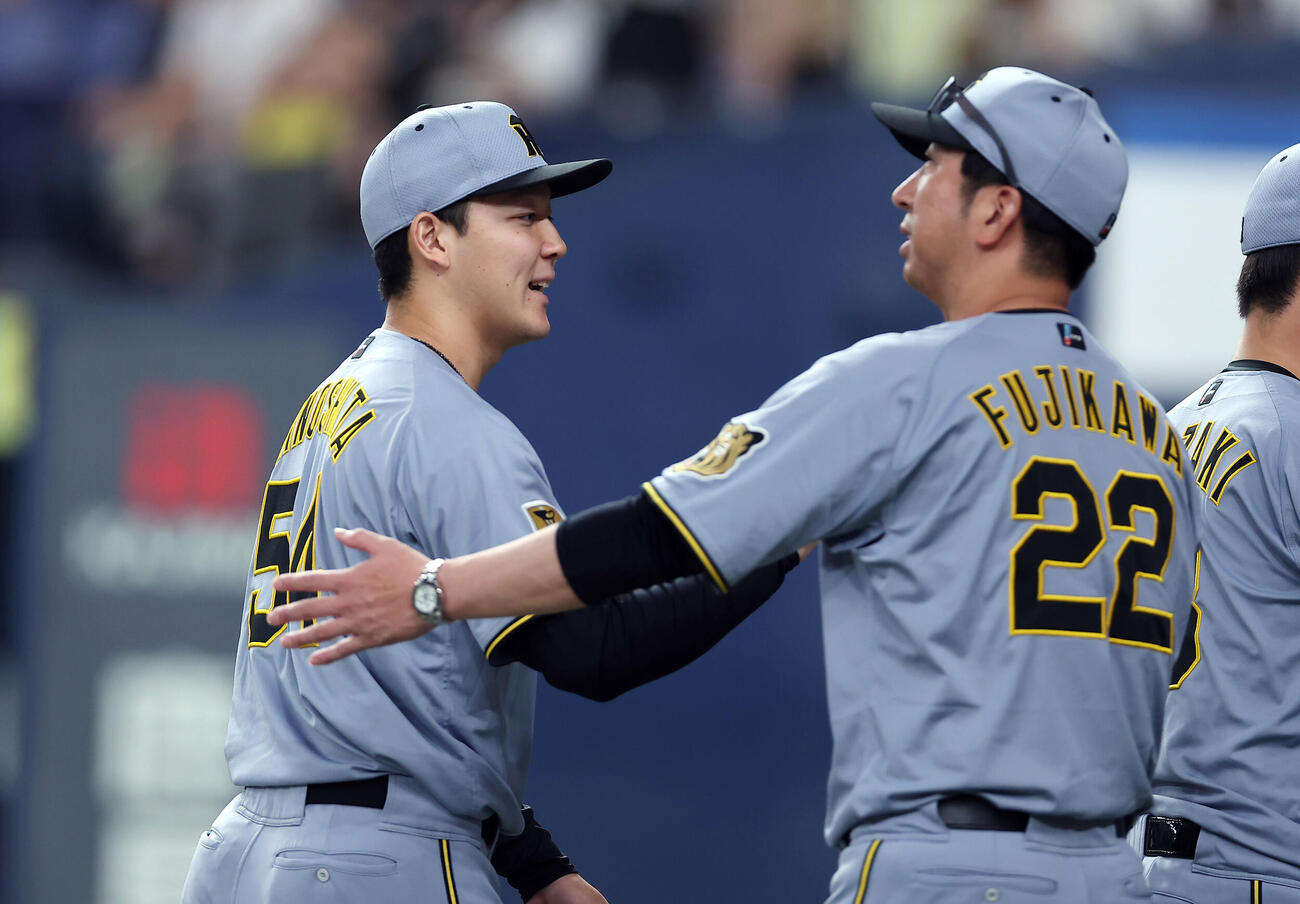 オリックス対阪神　オリックスに勝利し、藤川球児監督（右）とタッチを交わす阪神木下里都（撮影・前田充）