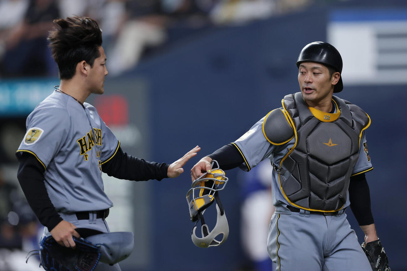 オリックス対阪神　8回裏のオリックス打線を抑え、タッチを交わす阪神坂本誠志郎（右）と木下里都（撮影・前田充）＝2026年6月14日