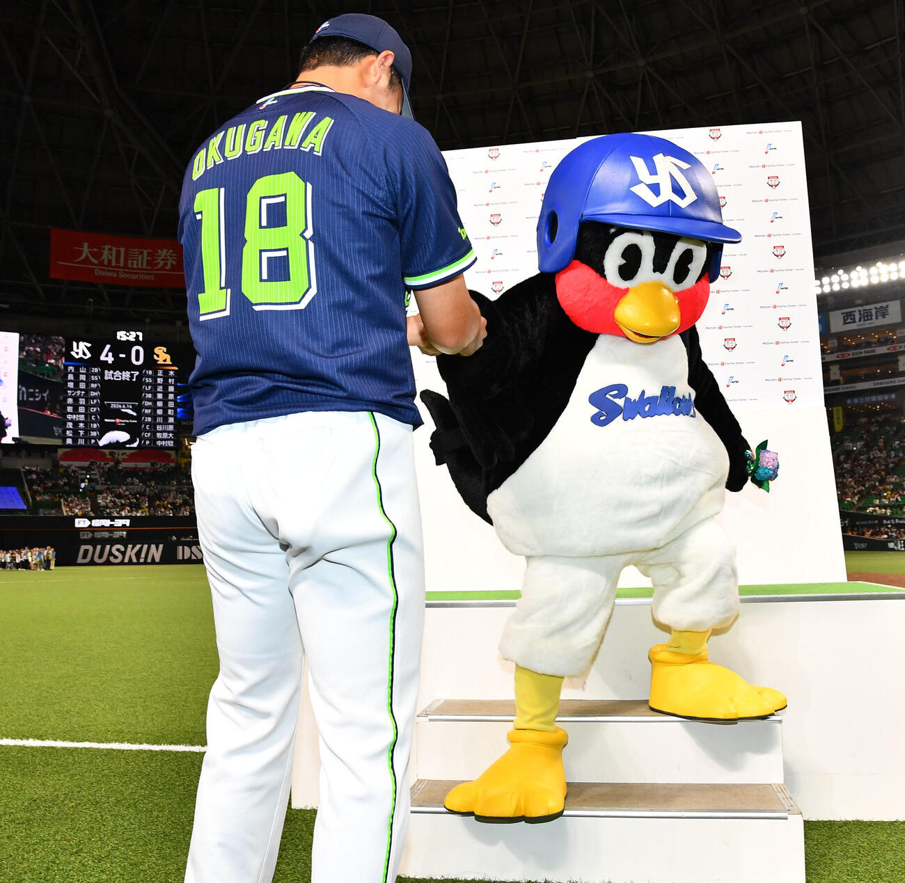 ソフトバンク対ヤクルト　プロ初完封の奥川恭伸（左）はお立ち台から下りるつば九郎の手を取る（撮影・岩下翔太）