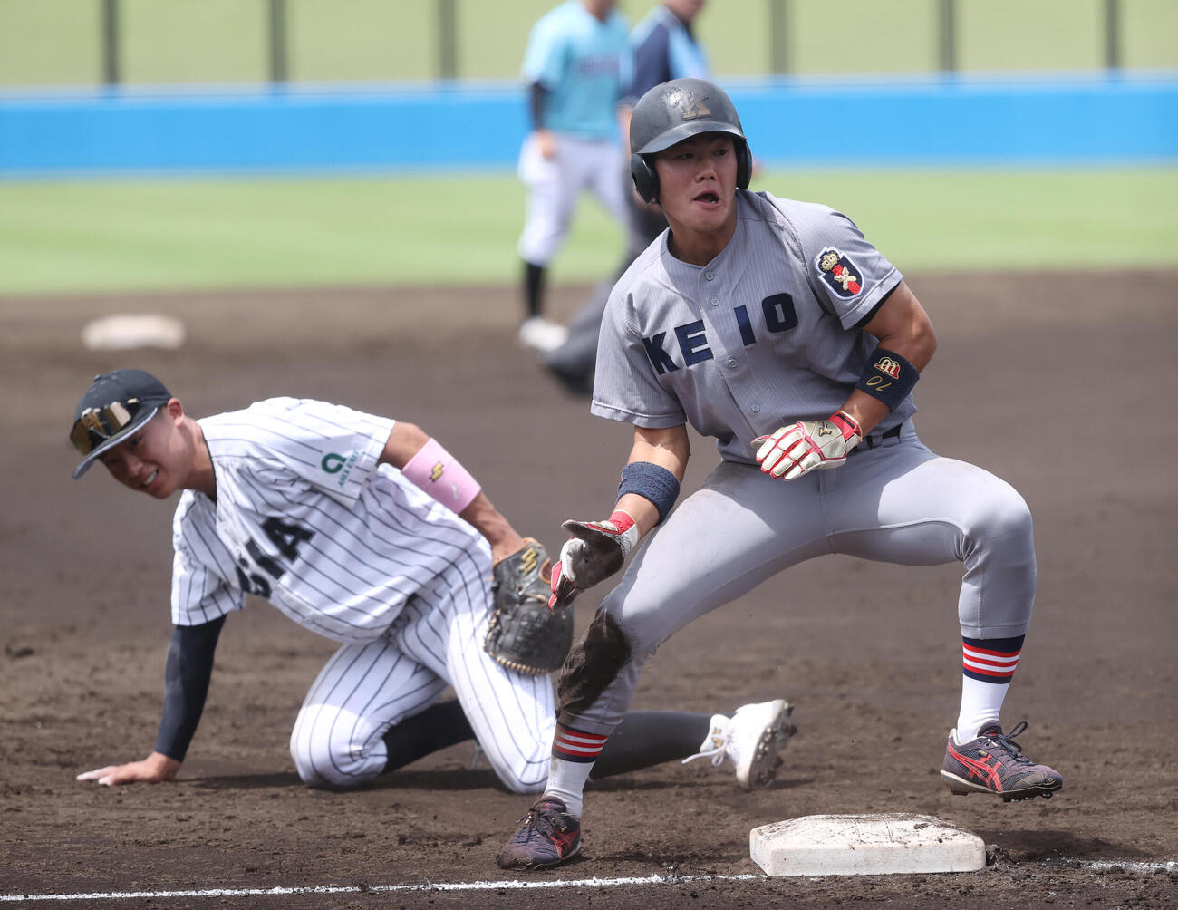 3回表A組2死一塁、神奈川大・神田剛志の右前安打で一塁走者の慶大・今津慶介（左）が三塁を陥れる、相手のエラーで生還する。左は亜大・山里宝三塁手（撮影・柴田隆二）