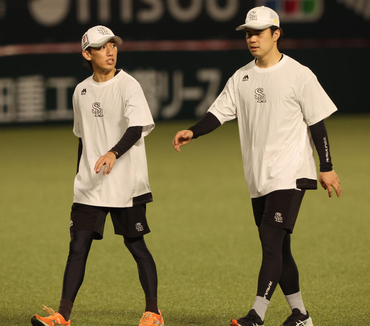 練習前、松本輝と話をしながら体をほぐすソフトバンク大津亮介（撮影・梅根麻紀）