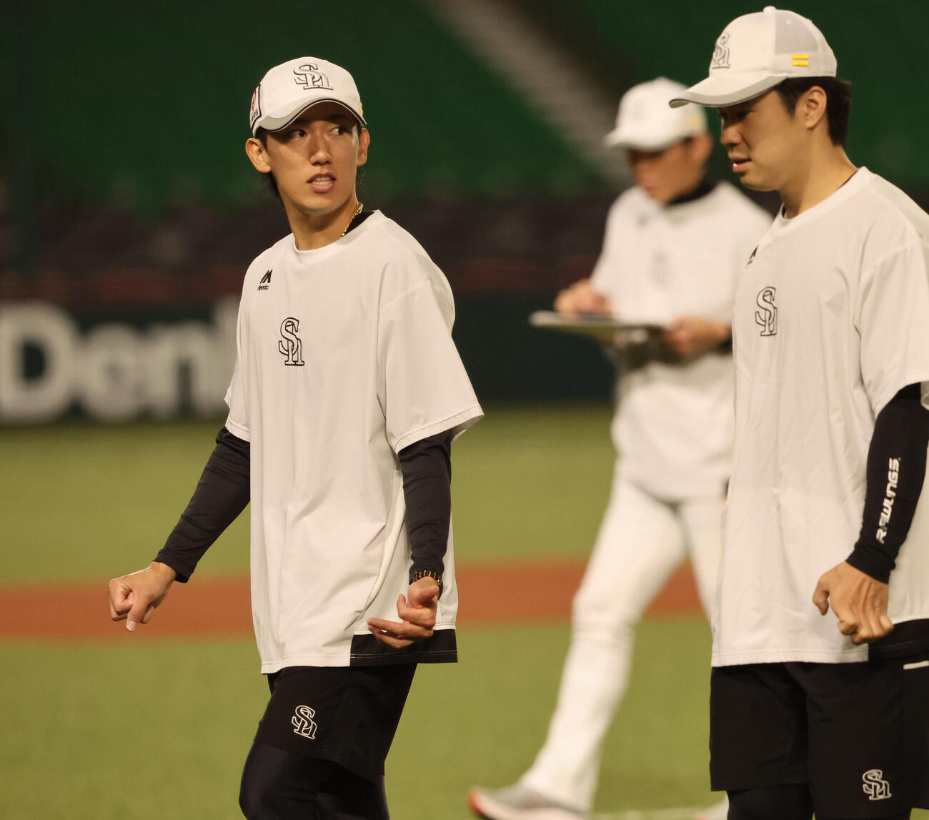 練習前、松本輝と話をしながら体をほぐすソフトバンク大津亮介（撮影・梅根麻紀）