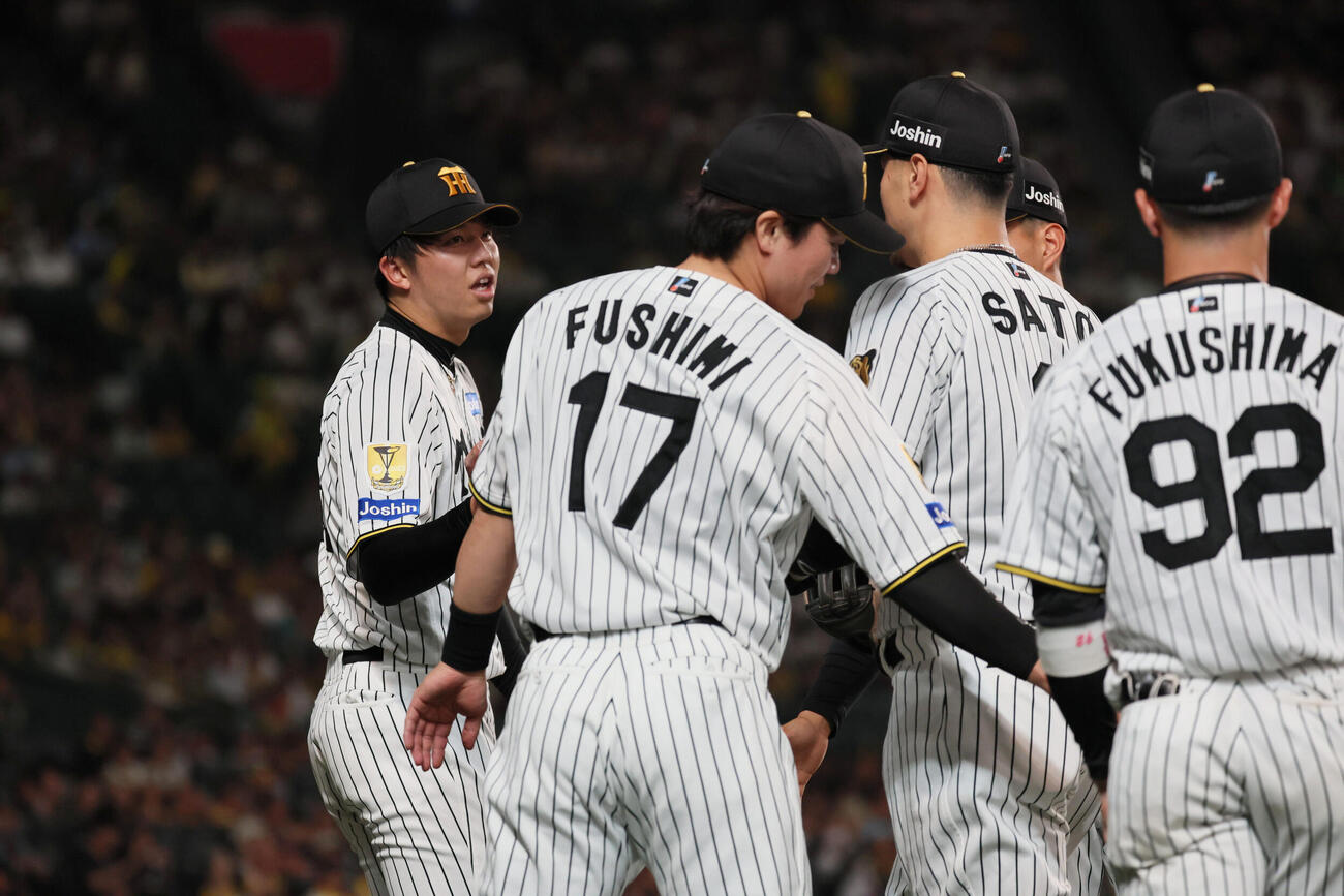 阪神対西武　6回表西武2死一塁、阪神佐藤輝明は石井一成の飛球を好捕し、才木浩人（左）らに迎えられる（撮影・宮崎幸一）