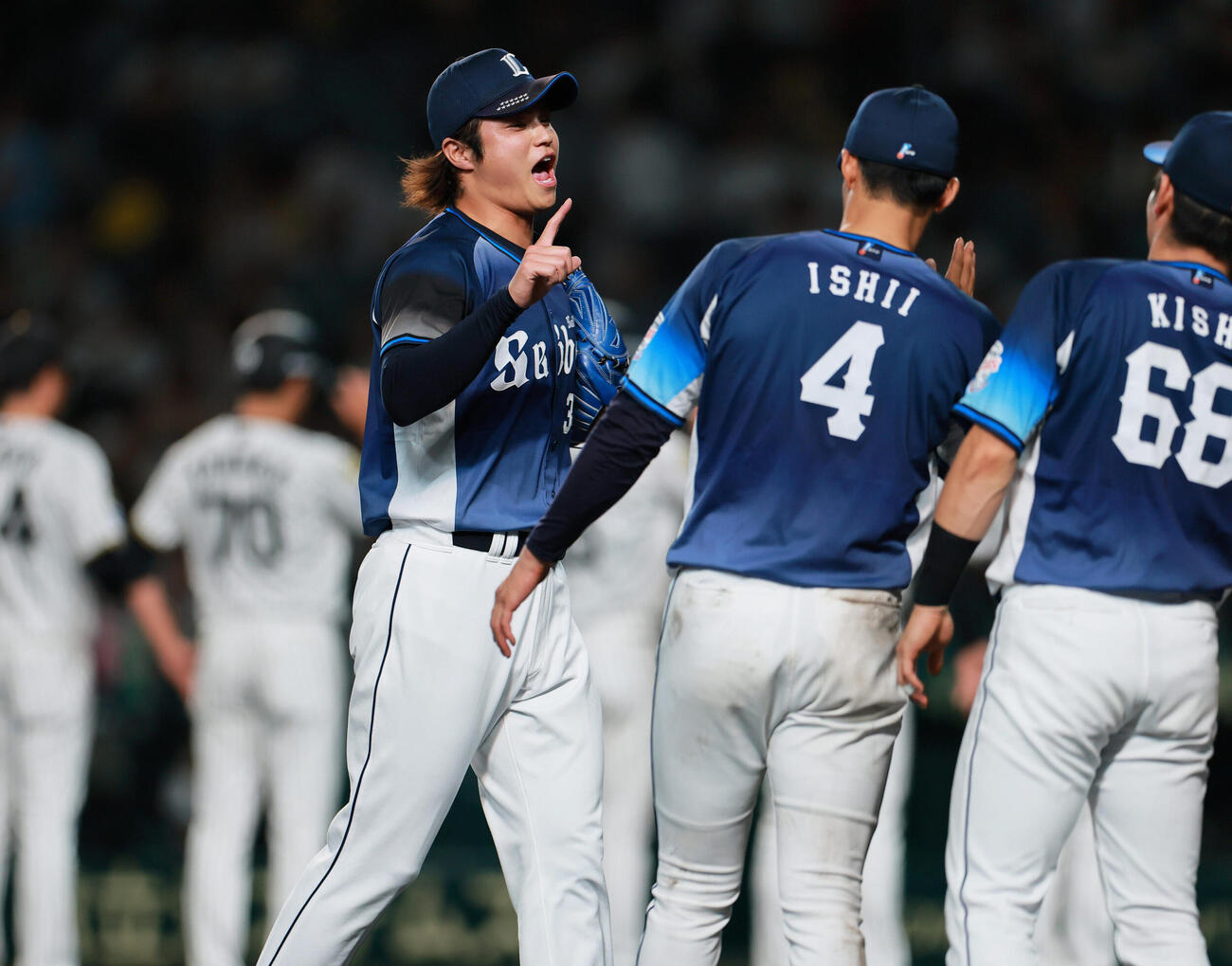 阪神対西武　阪神に勝利し、試合を締めた甲斐野央（中央）は古賀悠斗とタッチをかわす（撮影・上山淳一）