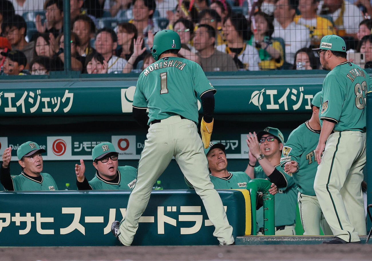 阪神対楽天　6回裏阪神1死一、三塁、三走森下翔太（手前）は高寺望夢のセーフティースクイズで生還し藤川球児監督（右）らの出迎えを受ける（撮影・上山淳一）