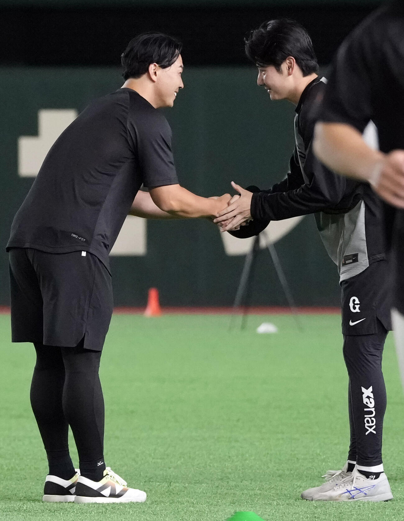 ウオーミングアップ後、握手する巨人小笠原慎之介（左）と竹丸和幸（撮影・小島史椰）　♯2026年6月18日、巨人全体練習