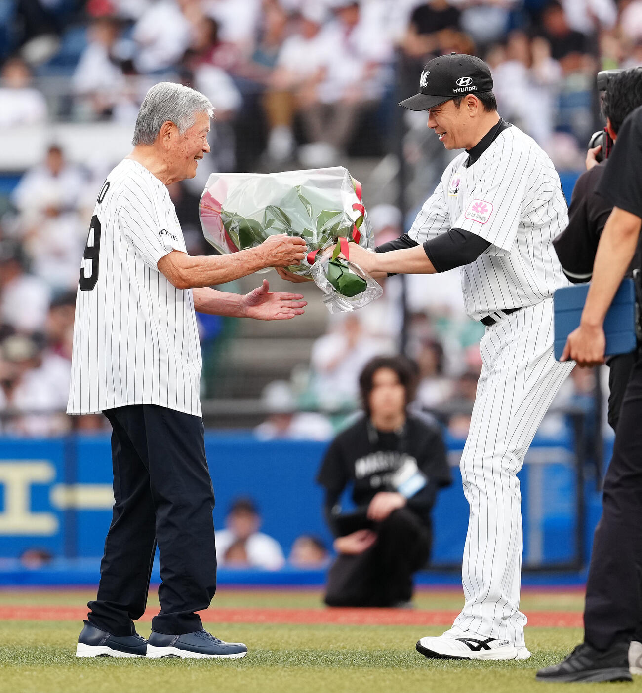 ロッテ対楽天　ファーストピッチを終えた日本トップリーグ連携機構川淵三郎会長（左）に花束を渡すロッテのサブロー監督（撮影・鈴木みどり）