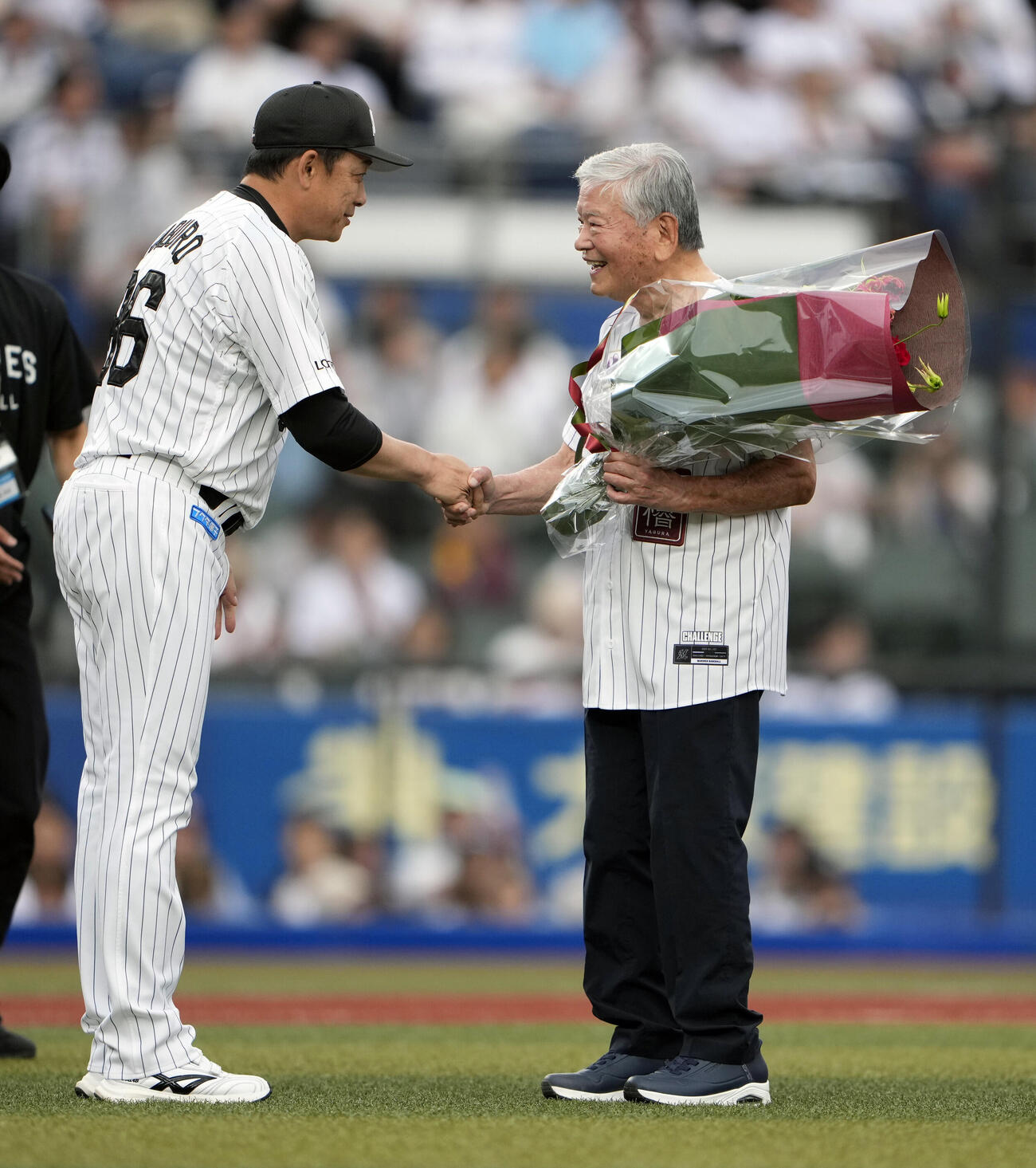 ロッテ対楽天　セレモニアピッチで花束を川淵三郎氏（右）に渡すロッテサブロー監督（撮影・小島史椰）