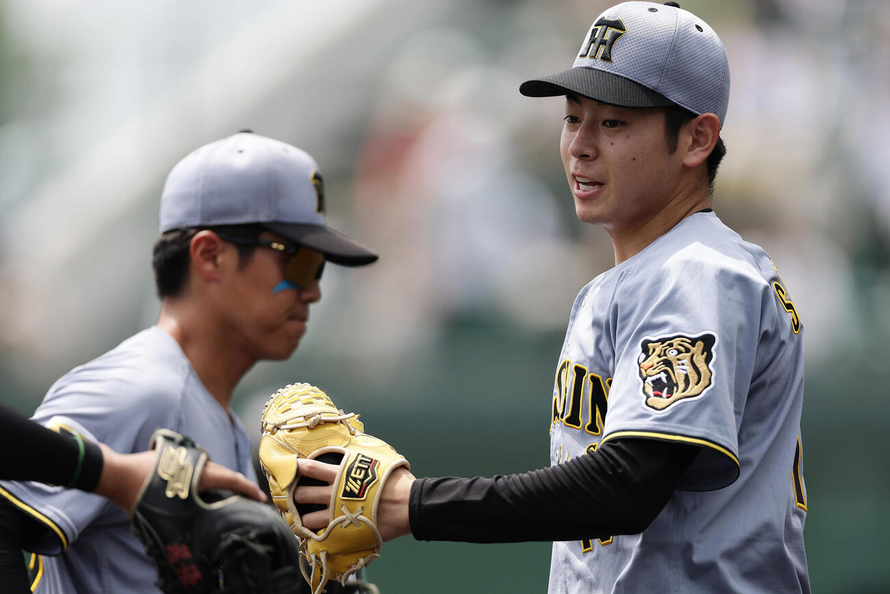 ファーム・リーグ西地区オリックス戦の2回を投げ終え、ナインとタッチを交わす阪神下村海翔（撮影・前田充）