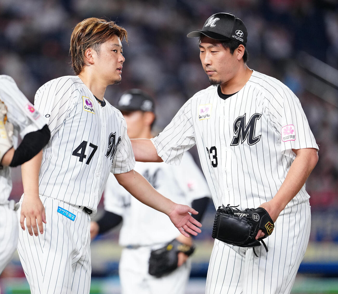 ロッテ対楽天　8回表を終え、鈴木昭汰（左）に迎えられるロッテ八木彬（撮影・鈴木みどり）