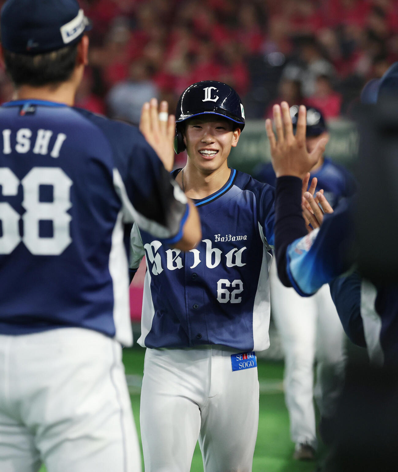 楽天対西武　3回表西武2死一、三塁、長谷川信哉の2点適時二塁打で生還しナインとタッチを交わす滝沢夏央（撮影・増田悦実）