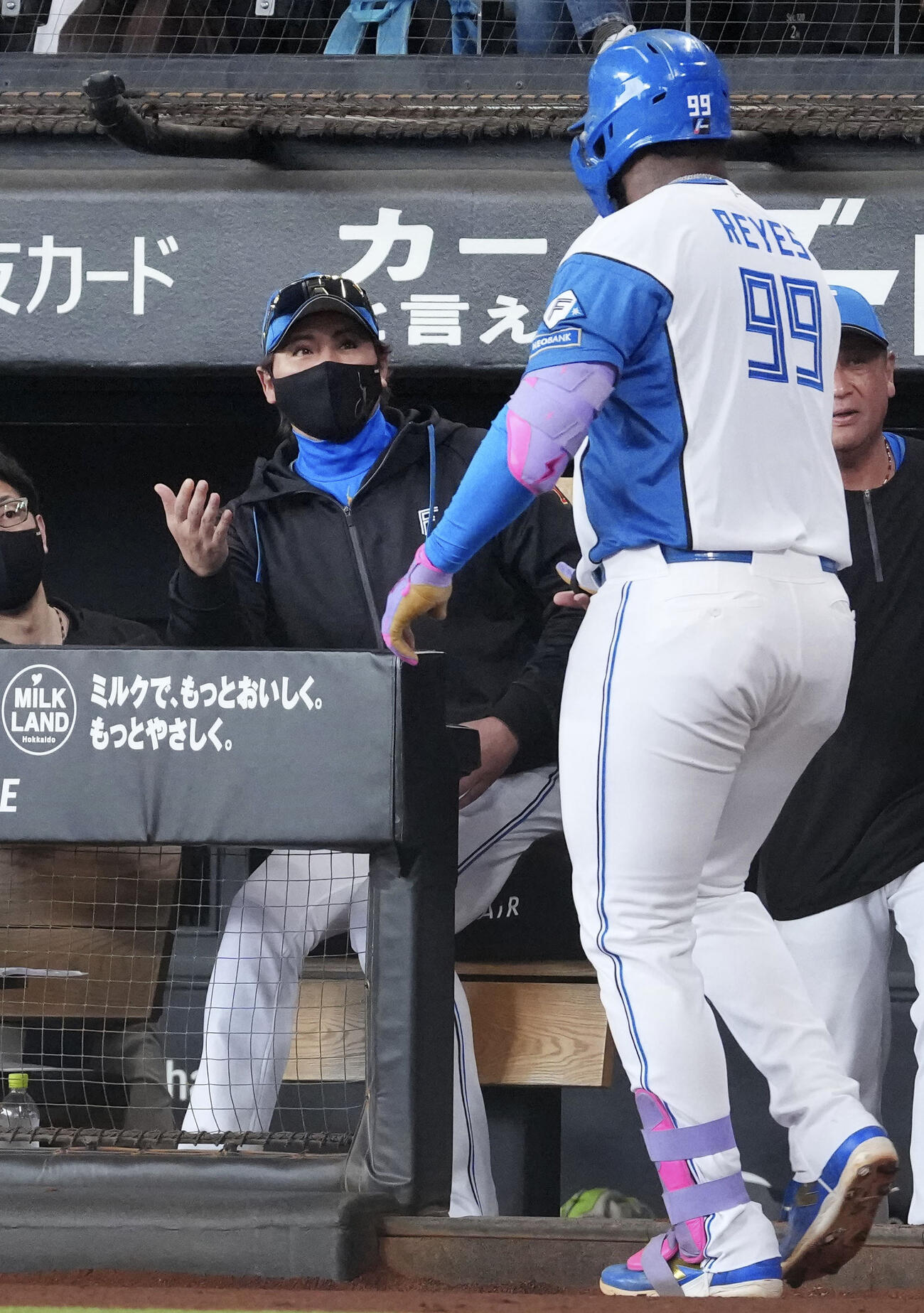 1回、先制ソロを放ったレイエス（手前）を迎える日本ハム・新庄監督＝エスコンフィールド（共同）