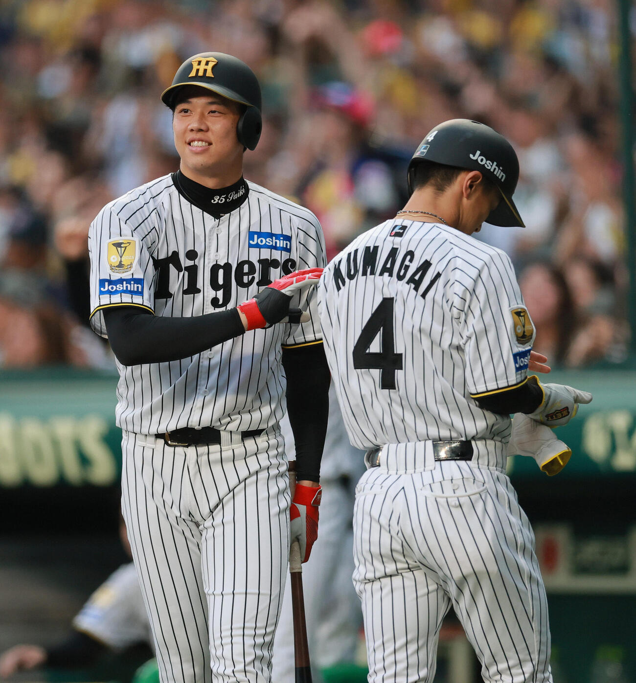 阪神対ヤクルト　2回裏阪神1死一、二塁、梅野隆太郎の右飛で右翼手モンテルの悪送球で先制し、生還した二走熊谷敬宥（手前）を出迎える才木浩人（撮影・上山淳一）