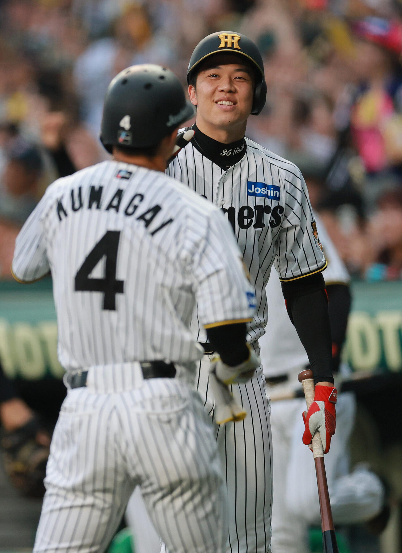 阪神対ヤクルト　2回裏阪神1死一、二塁、梅野隆太郎の右飛で右翼手モンテルの悪送球で先制し、生還した二走熊谷敬宥（手前）を出迎える才木浩人（撮影・上山淳一）