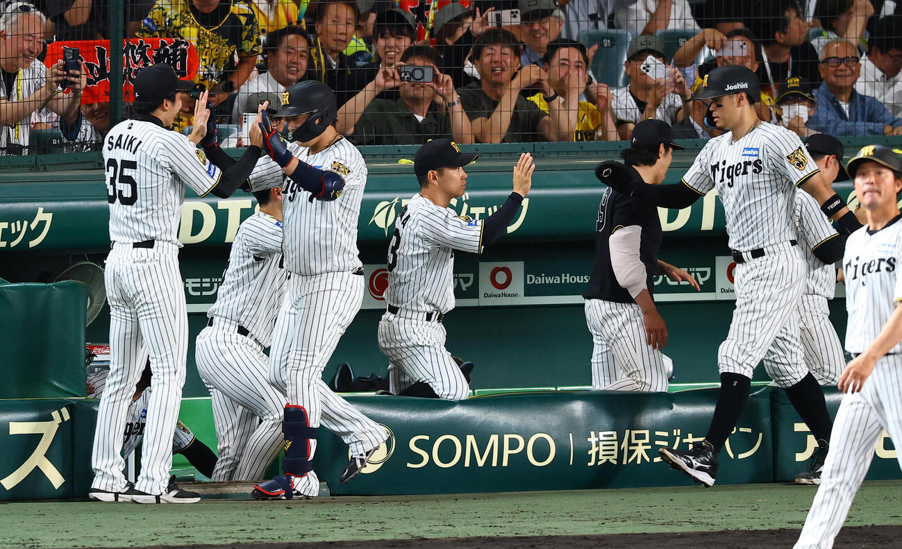 阪神対ヤクルト　8回裏阪神2死一塁、2点本塁打を放った大山悠輔（左から2人目）はナインの出迎えを受ける（撮影・上田博志)