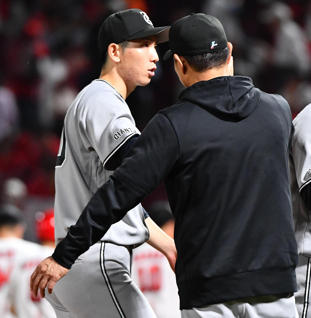 広島対巨人　今季4勝目を挙げた戸郷翔征（左）は橋上秀樹監督代行とタッチを交わす（撮影・岩下翔太）