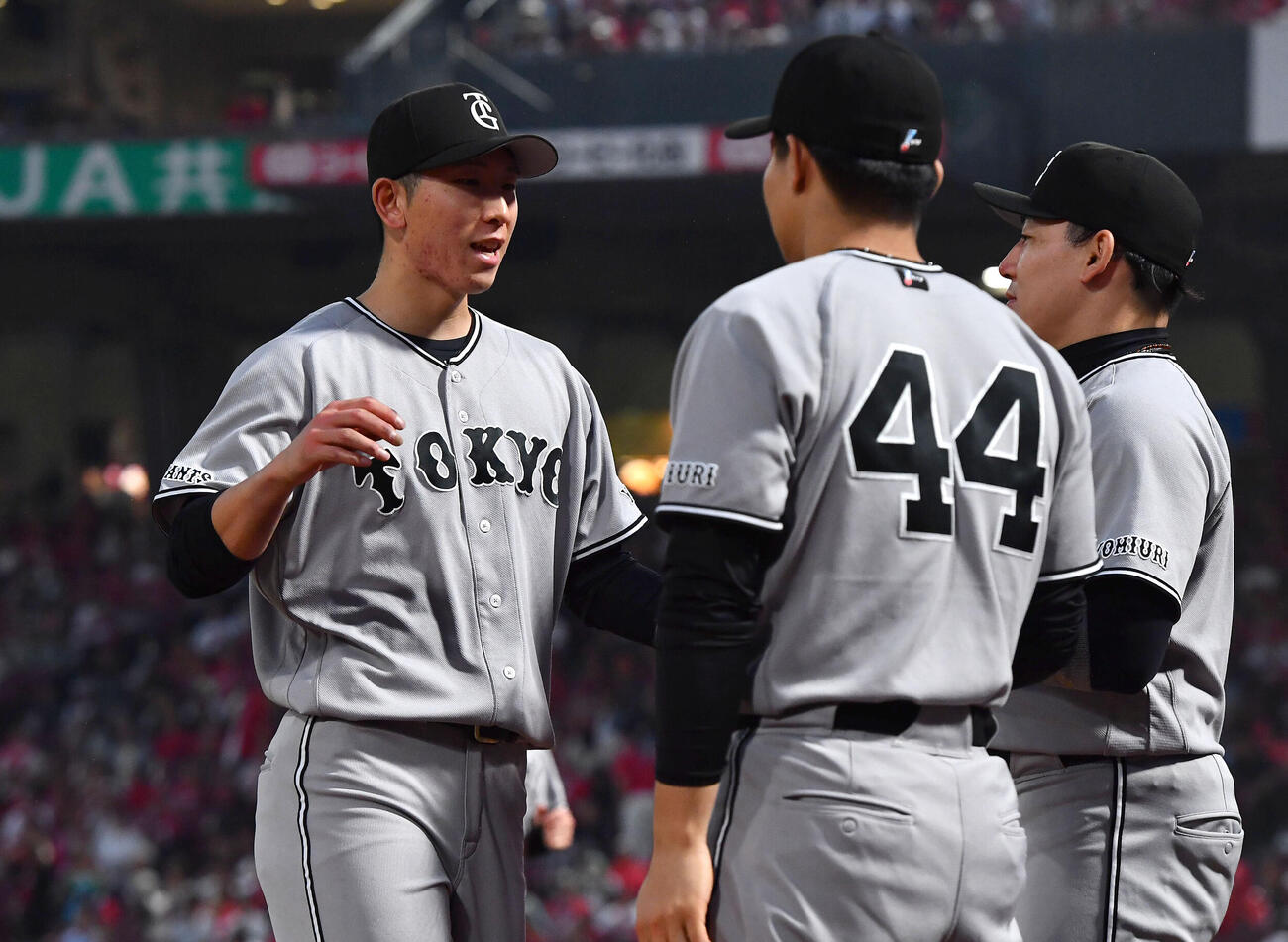 広島対巨人　5回裏を無失点に抑えた戸郷翔征（左）は、右から丸佳浩、佐々木俊輔とタッチを交わしながらベンチへ戻る（撮影・岩下翔太）