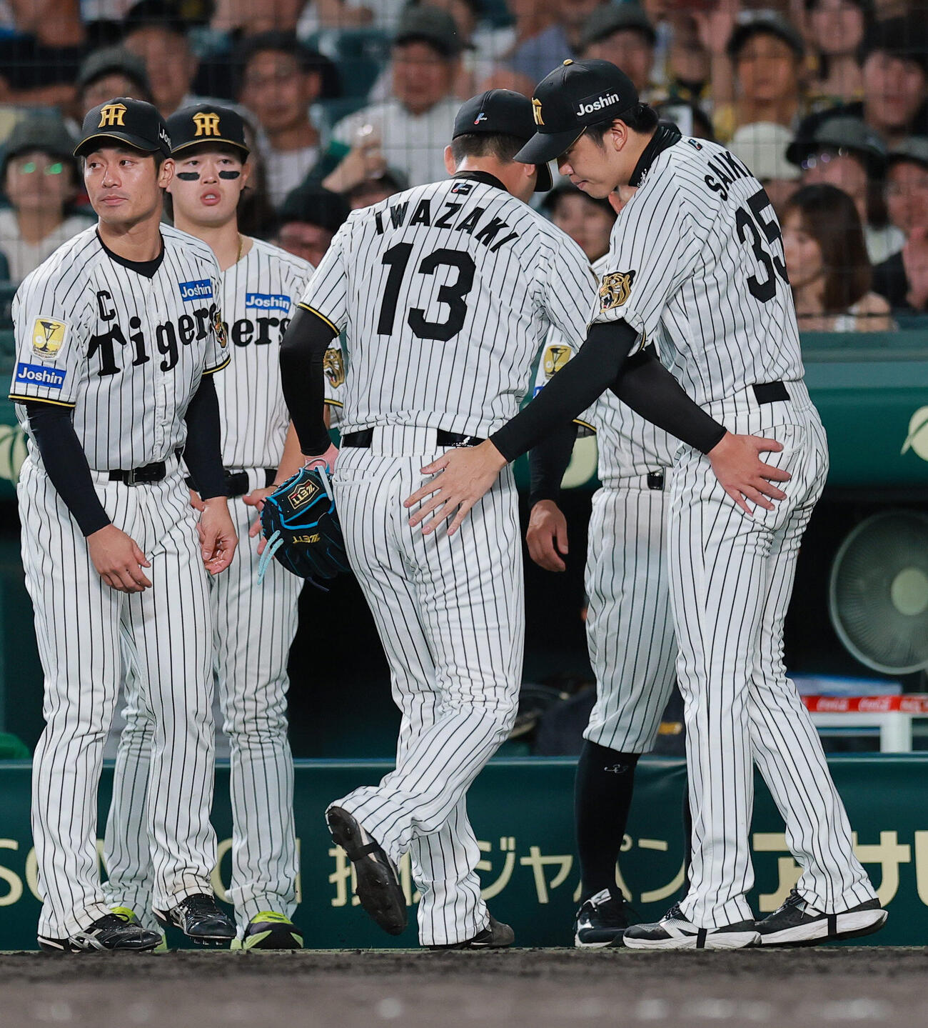 阪神対ヤクルト　8回表に登板し、4失点で降板となった岩崎優（手前）をねぎらう才木浩人（右）（撮影・上山淳一）
