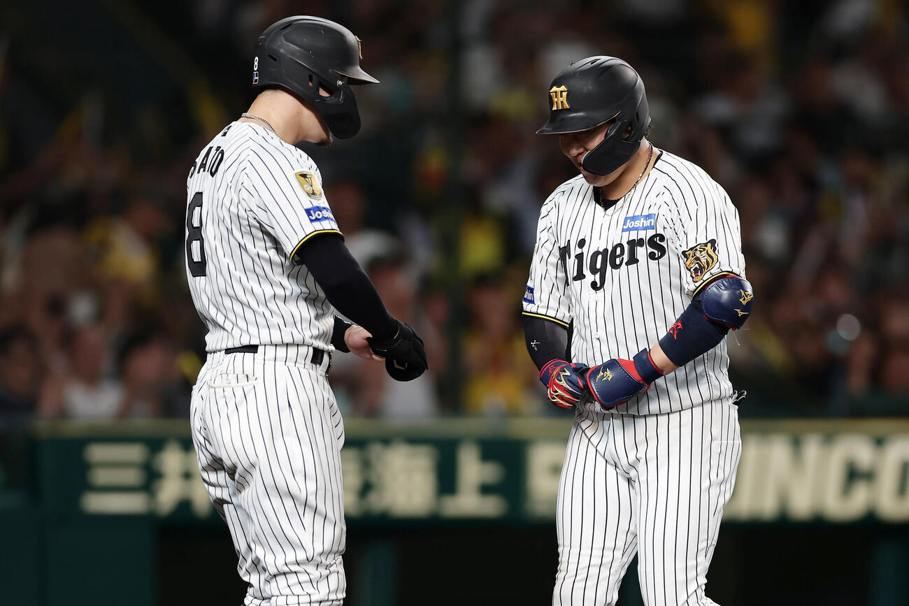 阪神対ヤクルト　8回裏阪神2死一塁、2点本塁打を放ち、出迎えた佐藤輝明（左）とポーズをとる大山悠輔（撮影・前田充）