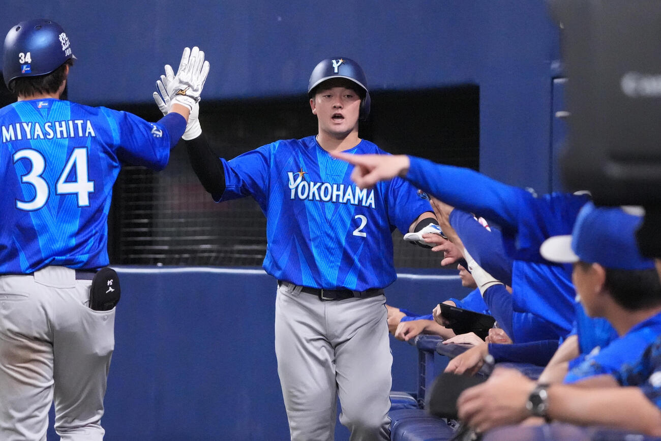 中日対DeNA 5回表DeNA1死満塁、牧秀悟（中央）は筒香嘉智の二ゴロの間に生還しナインとタッチを交わす（撮影・森本幸一）