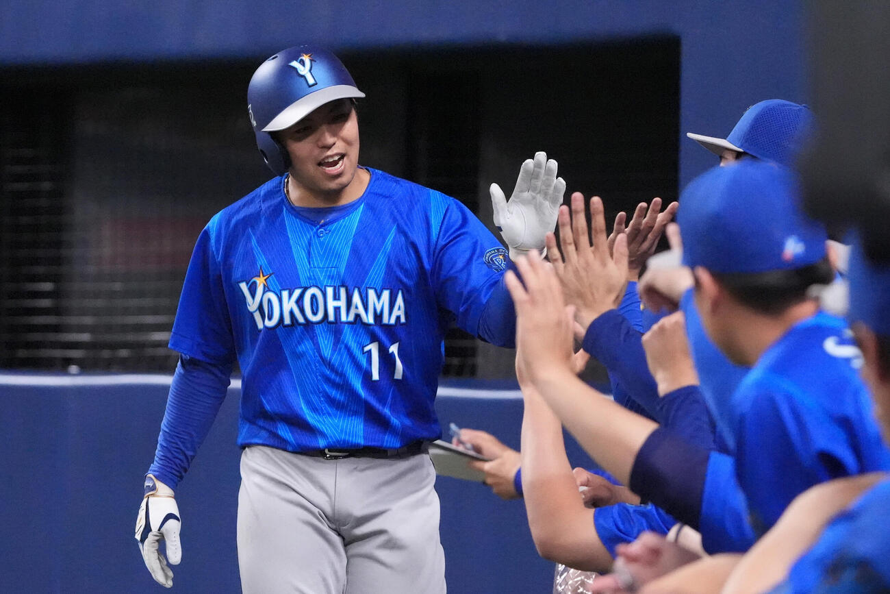 中日対DeNA 5回表DeNA1死二、三塁、東克樹（左）は牧秀悟の適時打で生還しナインとタッチを交わす（撮影・森本幸一）