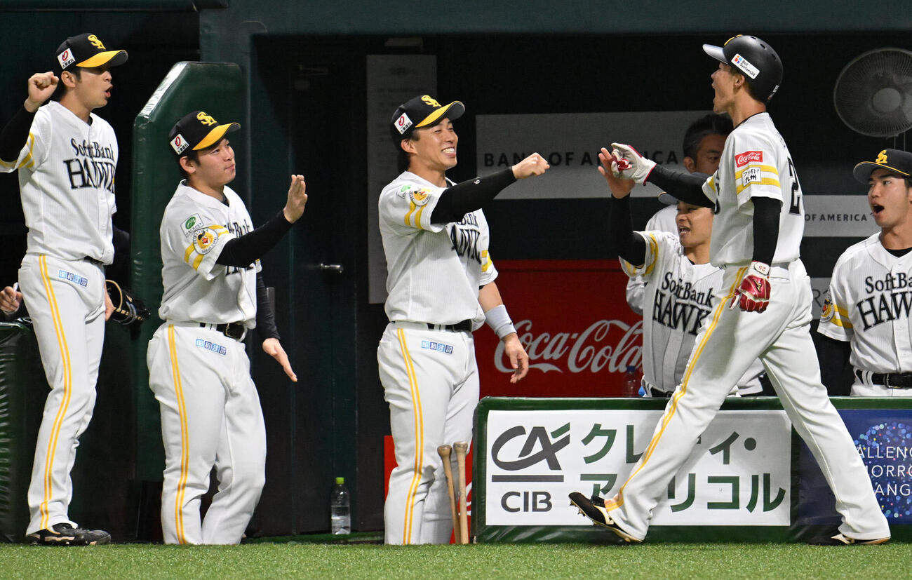ソフトバンク対オリックス　6回裏ソフトバンク2死二塁、正木智也の適時打で生還した庄子雄大（右）はナインとタッチを交わす（撮影・林敢治）