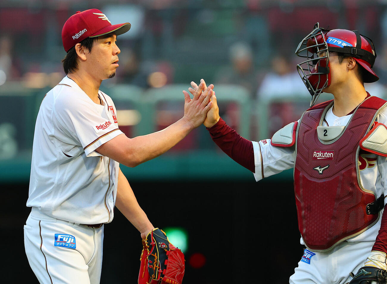 楽天対西武　2回表を終え、太田光（右）とタッチする楽天前田健太（撮影・野上伸悟）