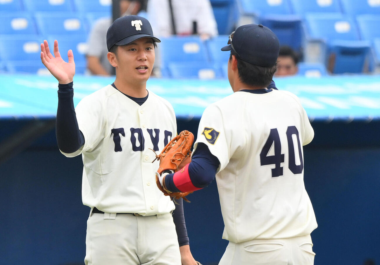 東洋大対専大　5回裏を投げ終え笑顔でナインを迎える東洋大先発石沢順平（左）（撮影・滝沢徹郎）