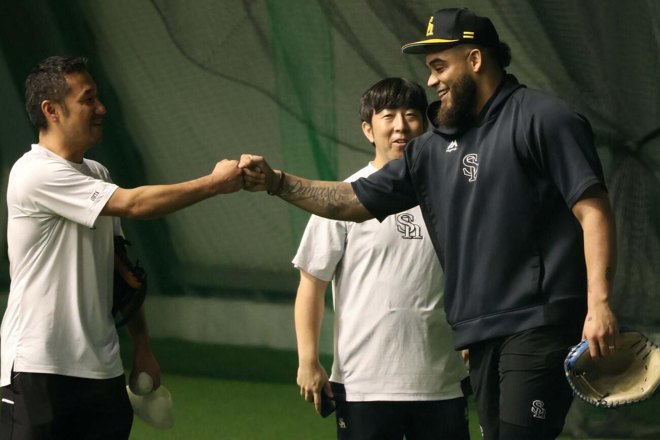トレーナー陣と笑顔でグータッチするソフトバンク・ヘルナンデス