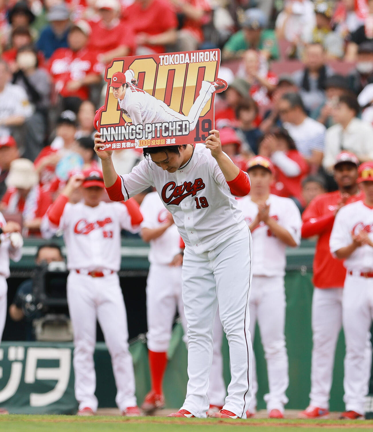 広島対阪神　1000イニングを記録し、記念ボードを手にスタンドの声援にあいさつする広島床田寛樹（撮影・上山淳一）