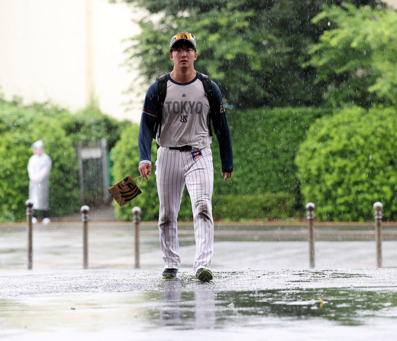 ヤクルト対中日　雨の中、室内練習場から引き揚げるヤクルト吉村貢司郎（撮影・浅見桂子）