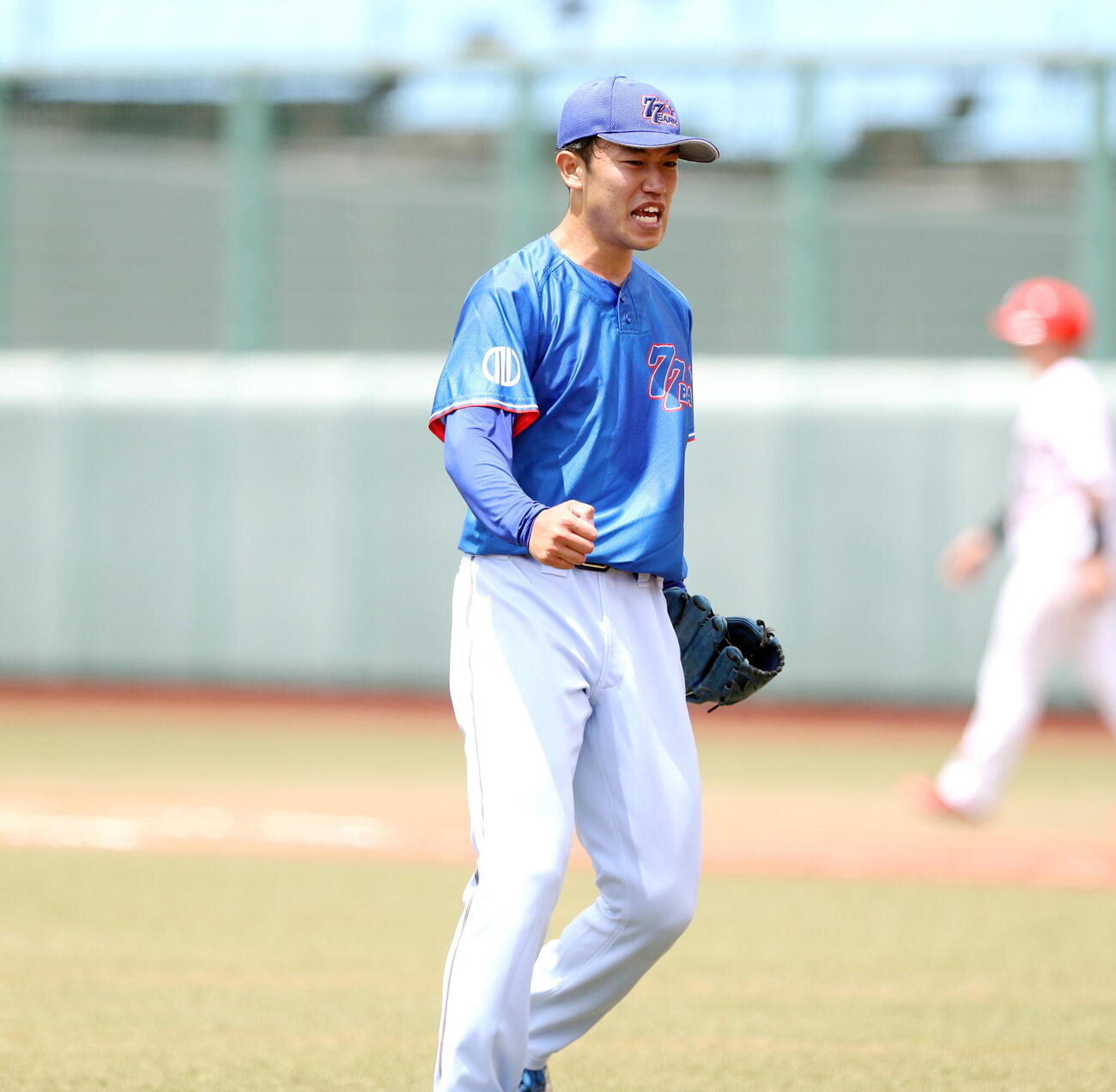 マルハン北日本カンパニー対七十七銀行　2回表2死一、二塁、無失点で切り抜け、ガッツポーズする七十七銀行・丸山陽太（撮影・木村有優）

