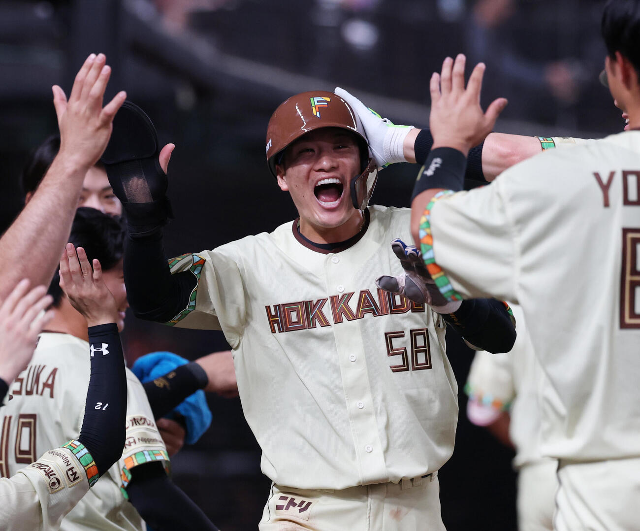 西武対日本ハム　9回表日本ハム2死二塁、水野達稀の適時三塁打で生還しナインとタッチを交わす奈良間大己（撮影・増田悦実）