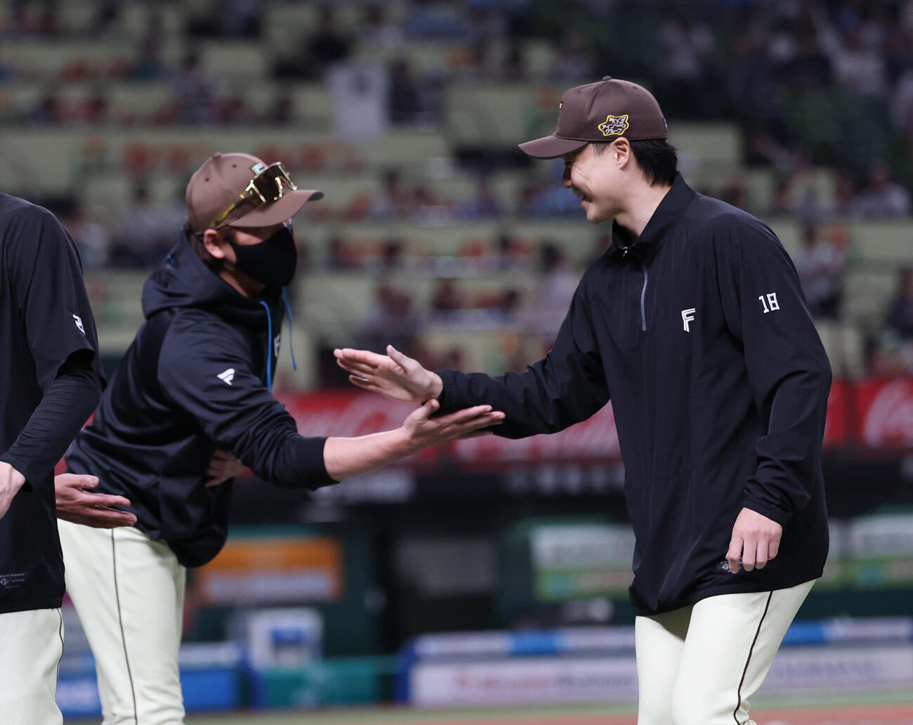 西武対日本ハム　勝利し山崎福也（右）ととタッチを交わす新庄剛志監督（撮影・増田悦実）