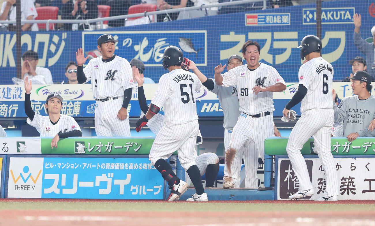 ロッテ対ソフトバンク　5回裏ロッテ2死一塁、左中間同点2点本塁打で生還し、チームメートに迎えられる山口航輝（中央）（撮影・河田真司）