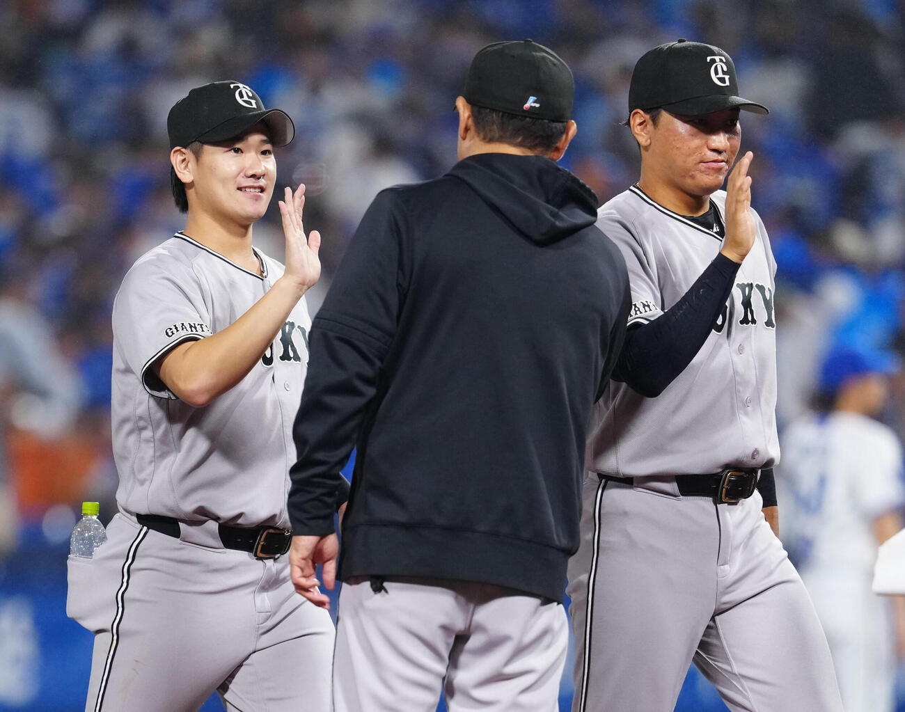 DeNA対巨人　試合後、巨人橋上秀樹監督代行（中央）とタッチを交わす井上温大。右は笹原操希（撮影・江口和貴）