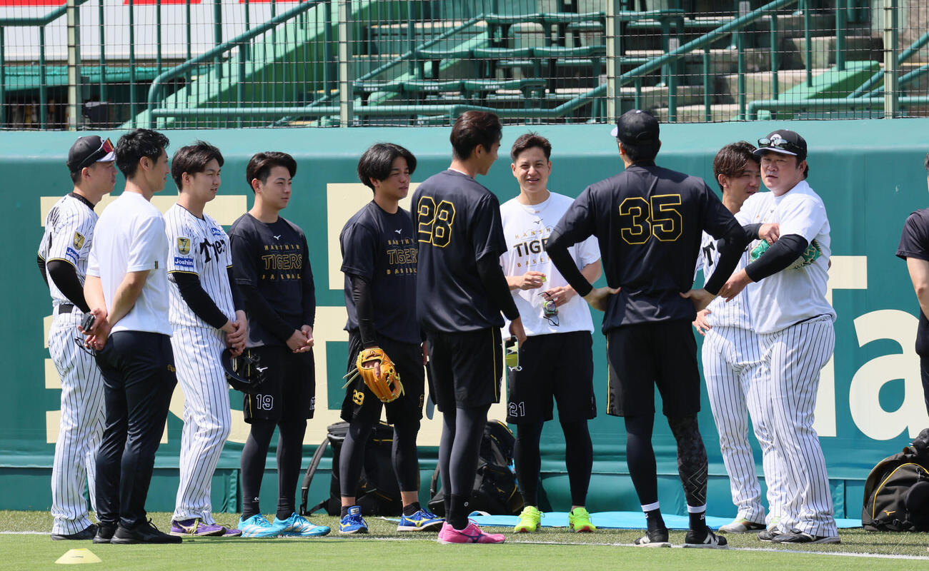 指名練習に集まり、安藤優也コーチ（右）の話を聞く阪神投手陣（撮影・宮崎幸一）