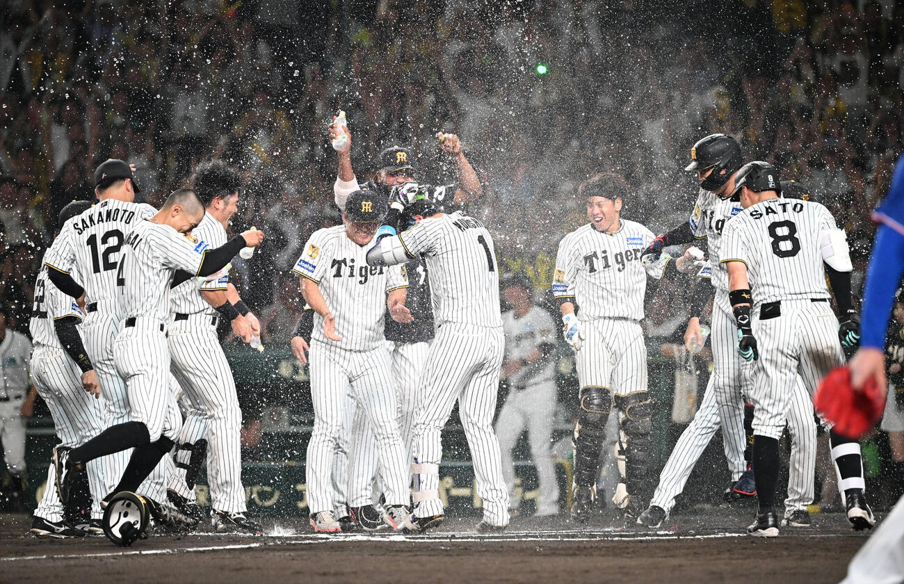 阪神対中日　10回裏阪神1死、サヨナラ本塁打を放った森下翔太はナインからウオーターシャワーを浴びながら生還する（撮影・和賀正仁）＝2026年6月30日、甲子園