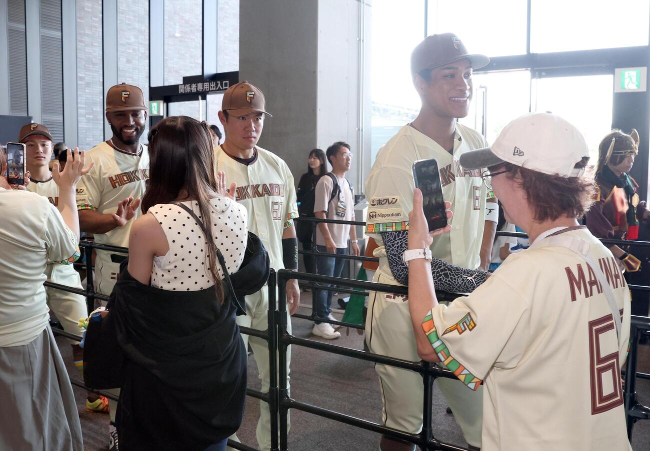 日本ハム対オリックス　　観客とウエルカムハイタッチする右から万波中正、吉田賢吾、カストロ（撮影・黒川智章）