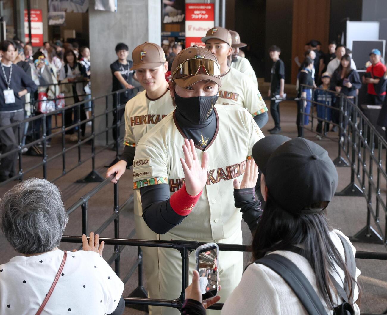 日本ハム対オリックス　　観客とウエルカムハイタッチする新庄剛志監督と選手たち（撮影・黒川智章）