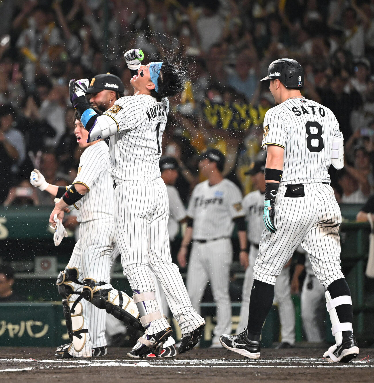 阪神対中日　10回裏阪神1死、サヨナラ本塁打を放った森下翔太（中央）はナインからウオーターシャワーを浴びガッツポーズ（撮影・和賀正仁）＝2026年6月30日、甲子園